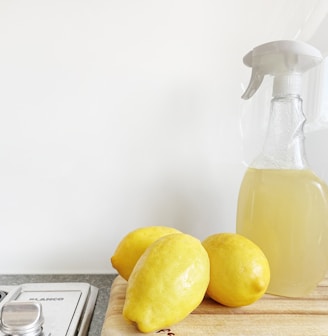 yellow lemon fruit beside clear glass bottle