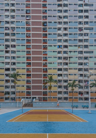 white and blue swimming pool near white concrete building during daytime