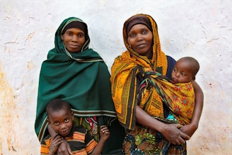woman in green hijab carrying baby