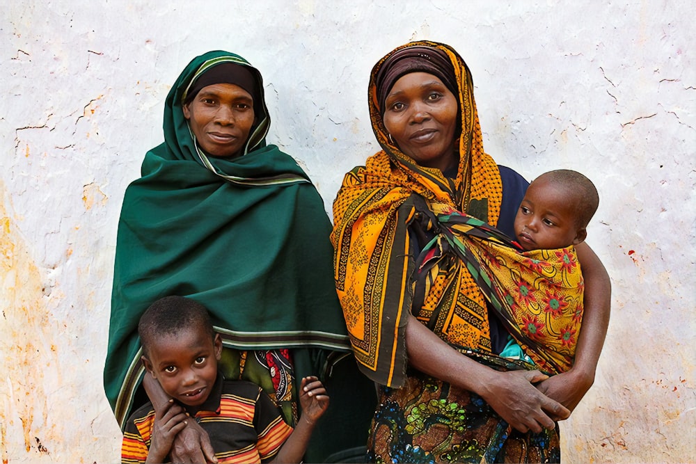 woman in green hijab carrying baby