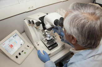 A modern lab technician carefully analyzing a hair follicle sample in a sleek, minimalist laboratory.