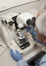 man in white shirt using white sewing machine