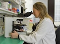 woman in white coat holding black dslr camera