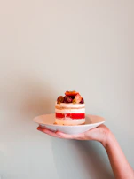 An inviting display of layered cakes with fresh fruit toppings on elegant white plates.