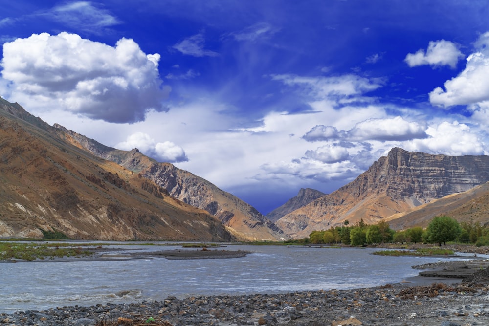 brown and green mountains under blue sky and white clouds during daytime