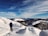 Traveler hiking along a scenic trail with snow-capped peaks in the background