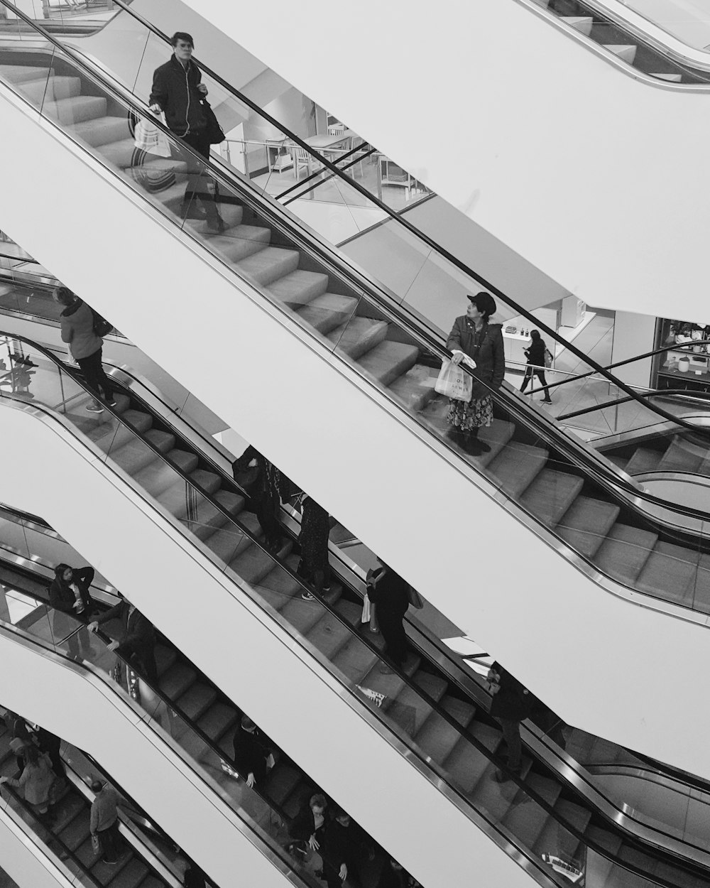 grayscale photo of people walking on stairs
