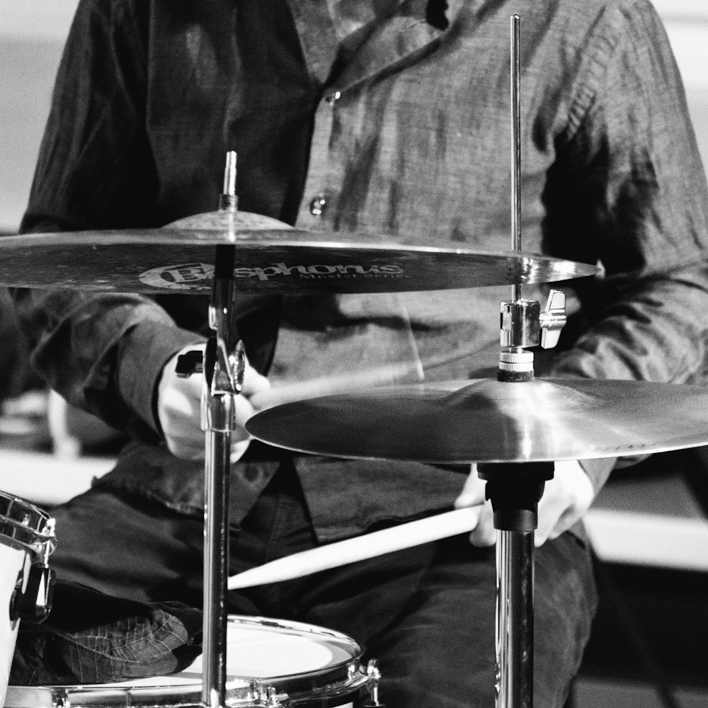 man in black dress shirt playing drum set