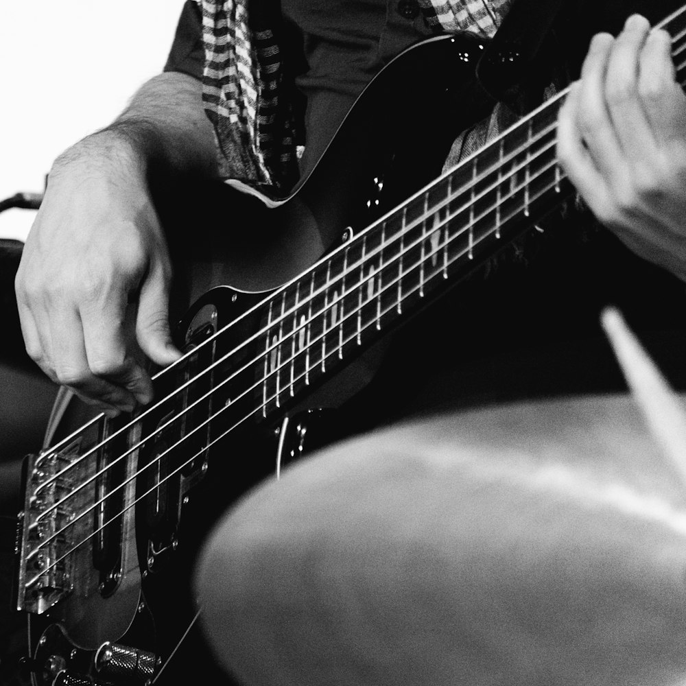 grayscale photo of man playing guitar