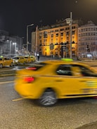 Modern taxi waiting in front of a historic Luzern building at dusk.