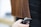 A person with long, straight brown hair is having their hair trimmed with electric clippers. The hair appears healthy and well-maintained, and the person performing the haircut is unseen, holding the clippers near the ends of the hair.