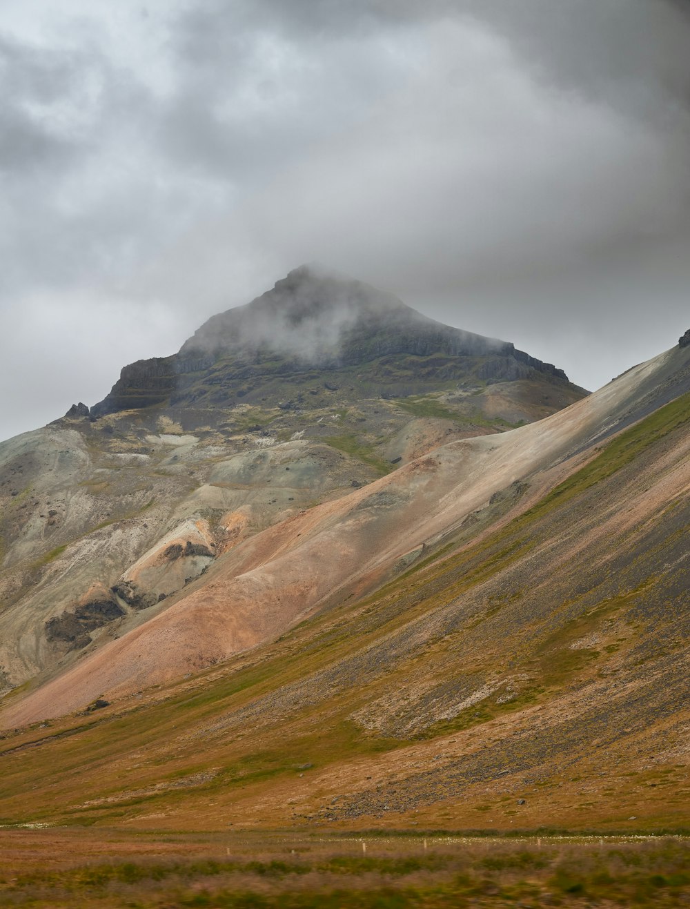 green and brown mountain under white clouds during daytime