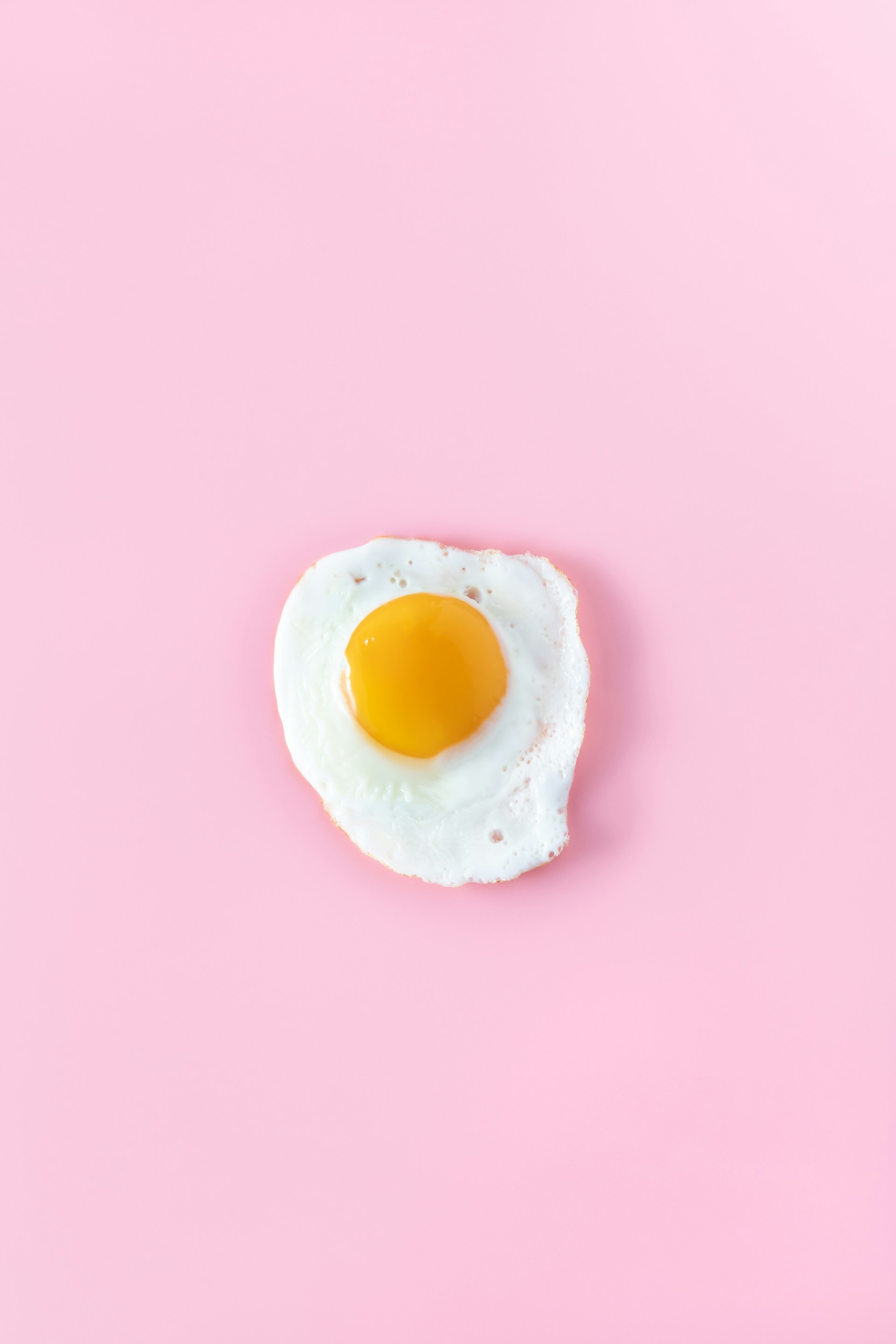 sunny side up egg on pink surface