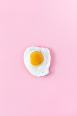 sunny side up egg on pink surface