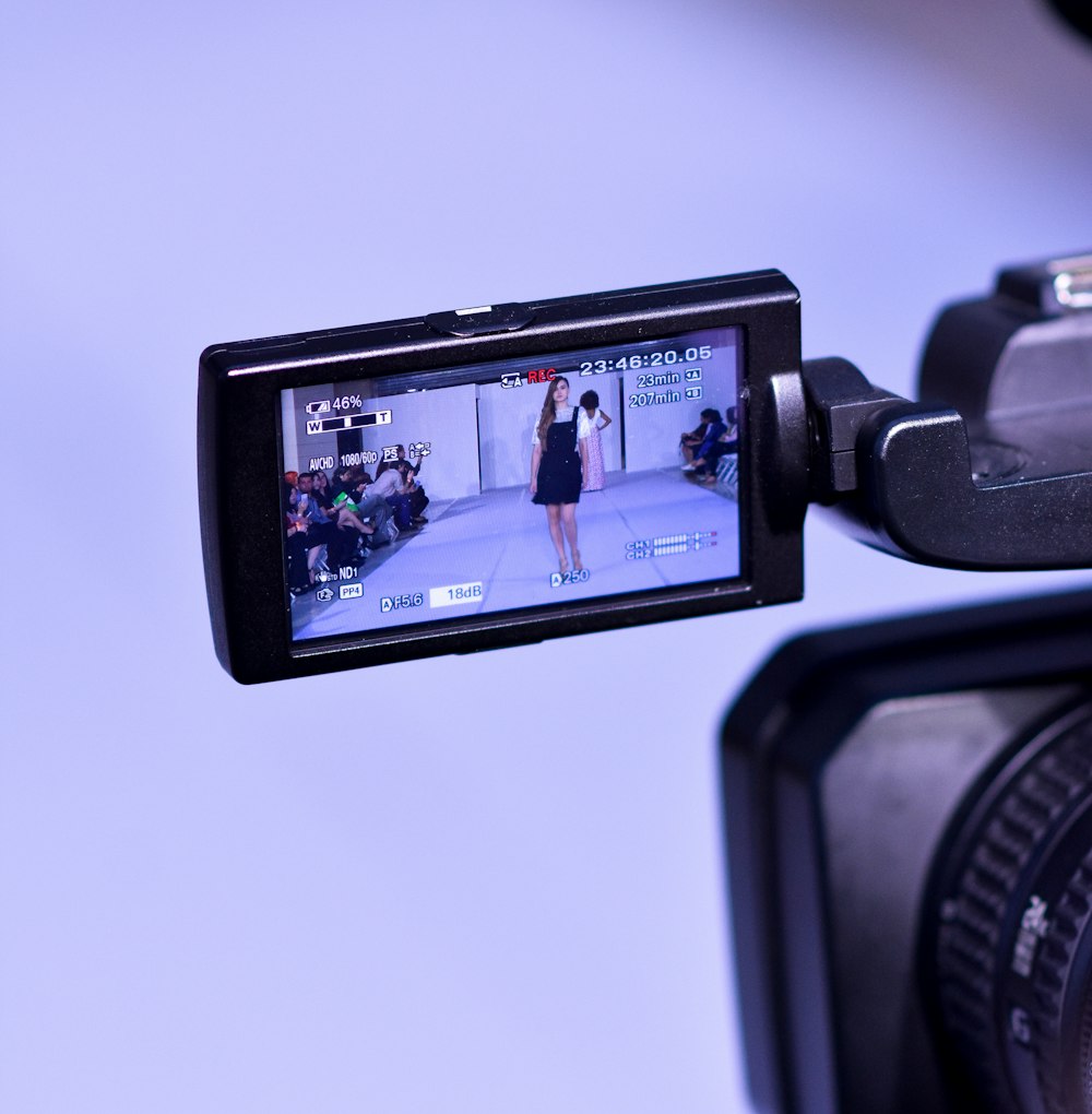 black digital camera showing man in orange shirt