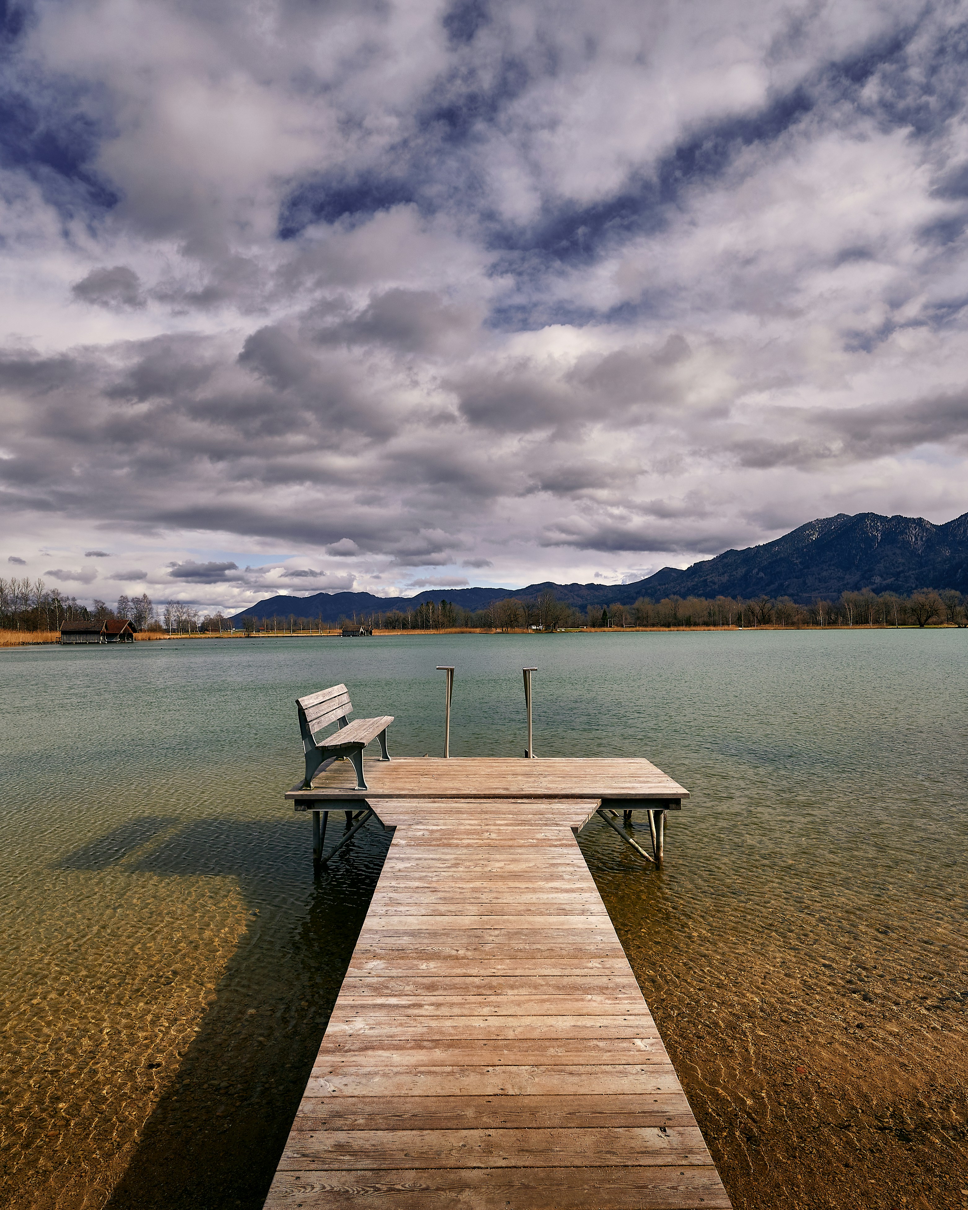 brown wooden dock on body of water under cloudy sky during daytime