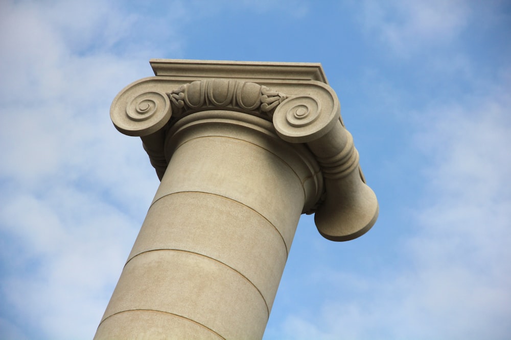 낮 동안 푸른 하늘 아래 흰색 콘크리트 기둥
