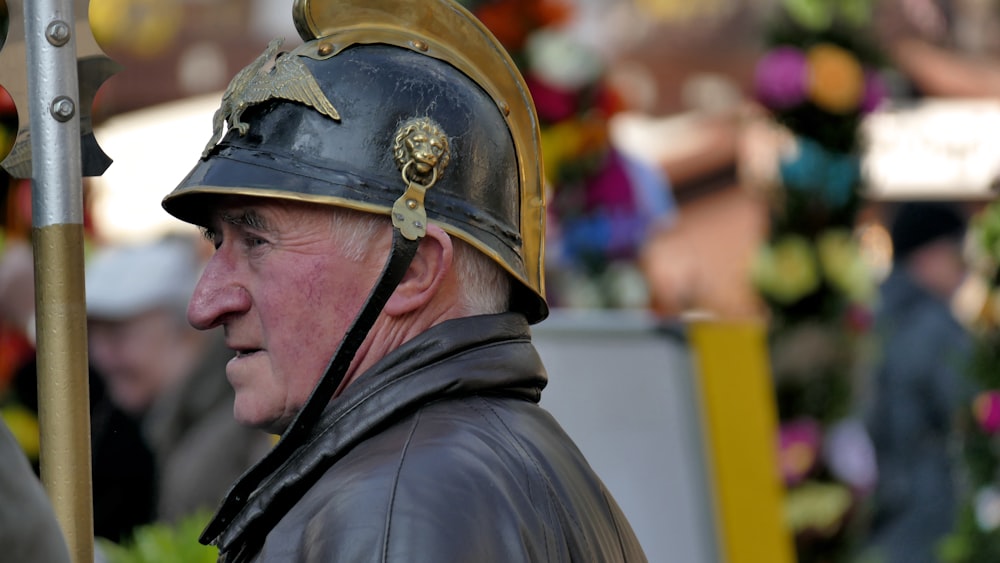 man in black leather jacket wearing gold helmet