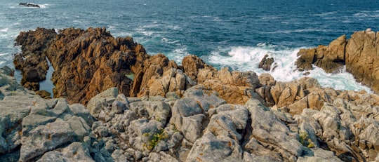 brown rocky mountain beside sea during daytime in A Coruña Spain