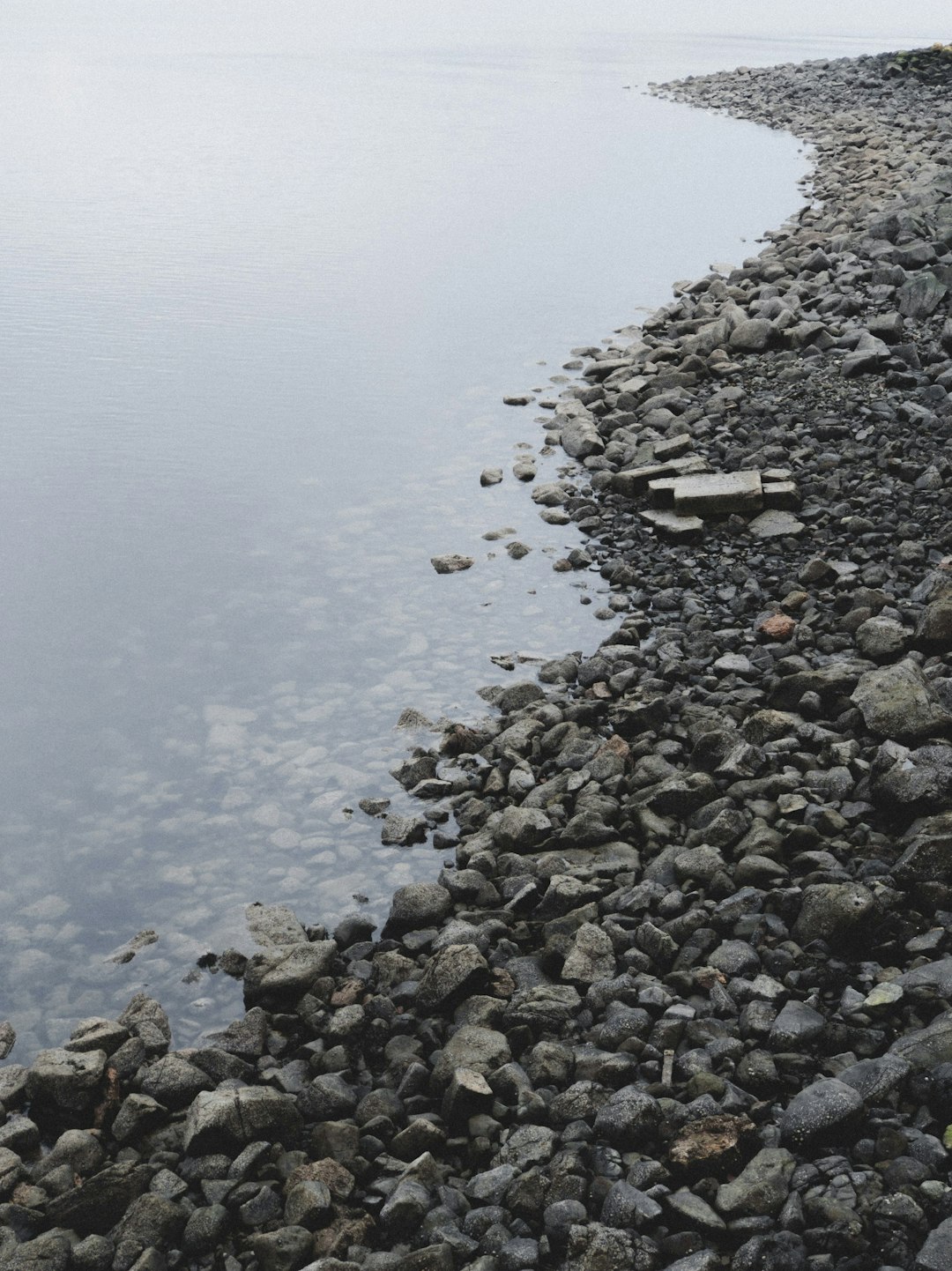 gray and black rocks on body of water during daytime