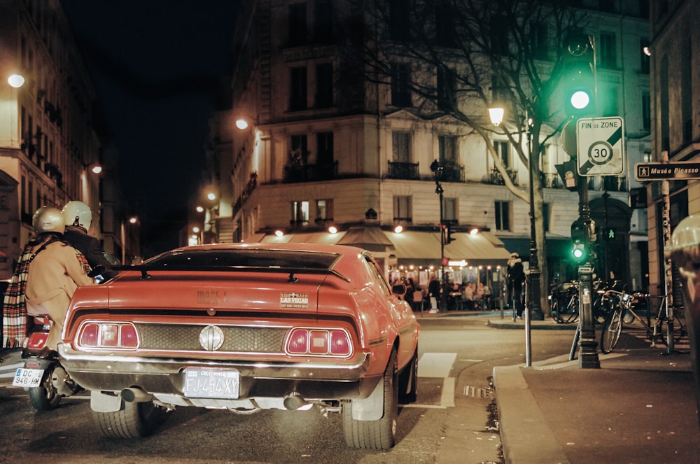 red car on the street during night time