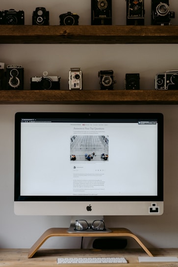 silver imac on brown wooden table