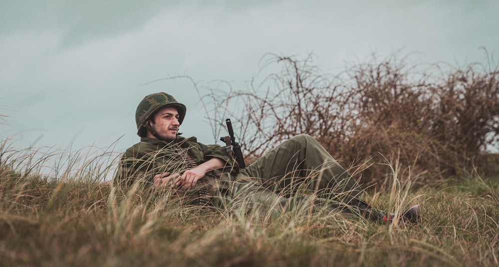 man in green and black camouflage uniform holding rifle