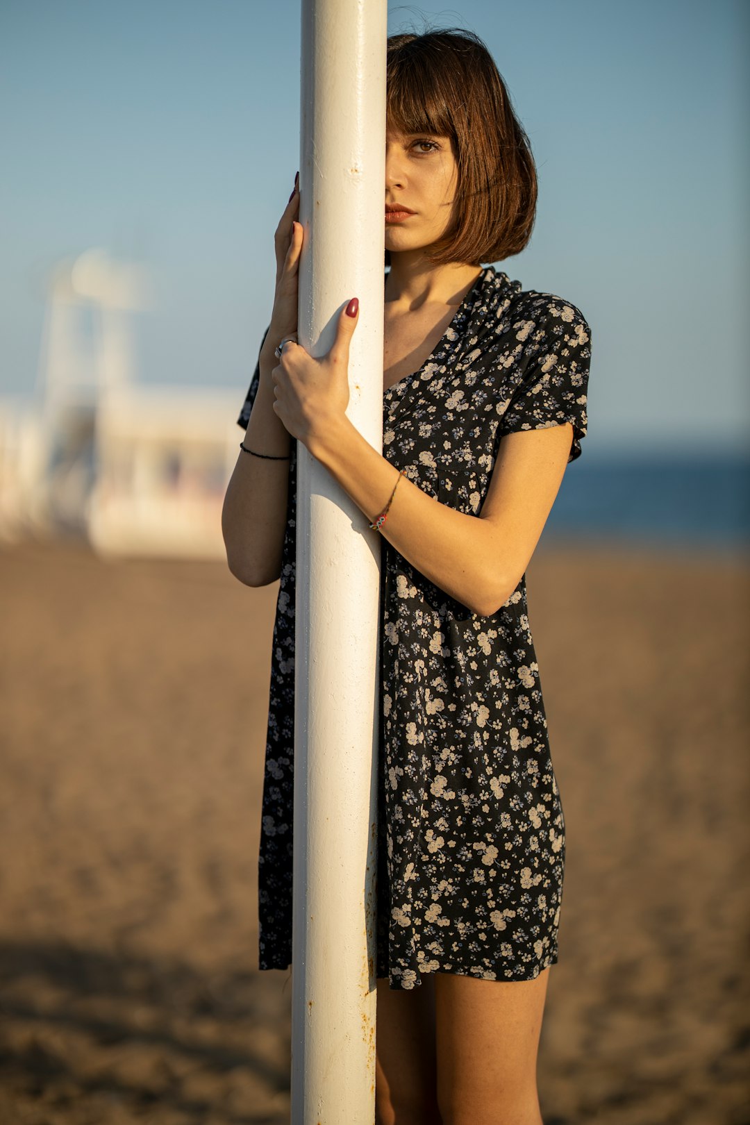 woman in black and white floral dress holding white pole