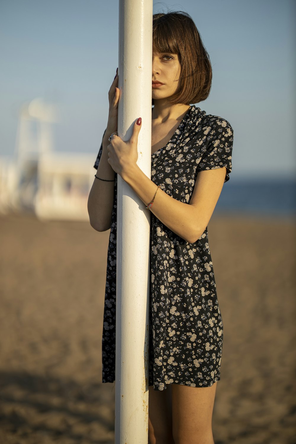 woman in black and white floral dress holding white pole