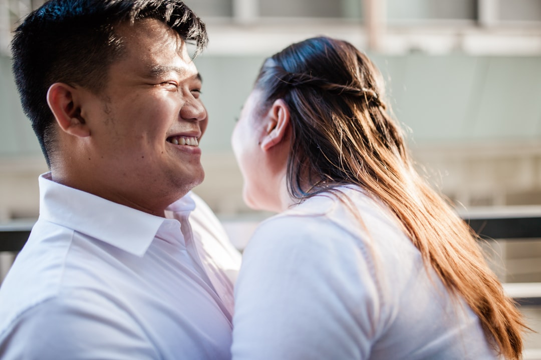 man in white polo shirt kissing woman in white shirt,