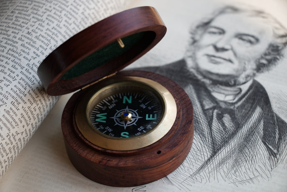 brauner holzgerahmter Kompass auf weißem Textil
