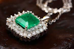 Happy customers wearing emerald jewelry with bright smiles.