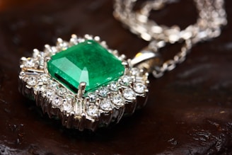 Thumbnail image of a glittering emerald pendant with silver chain