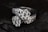 Two diamond rings featuring multiple small, clear diamonds arranged in a floral pattern set against a dark, contrasting background that enhances their sparkle.