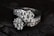 Two diamond rings featuring multiple small, clear diamonds arranged in a floral pattern set against a dark, contrasting background that enhances their sparkle.