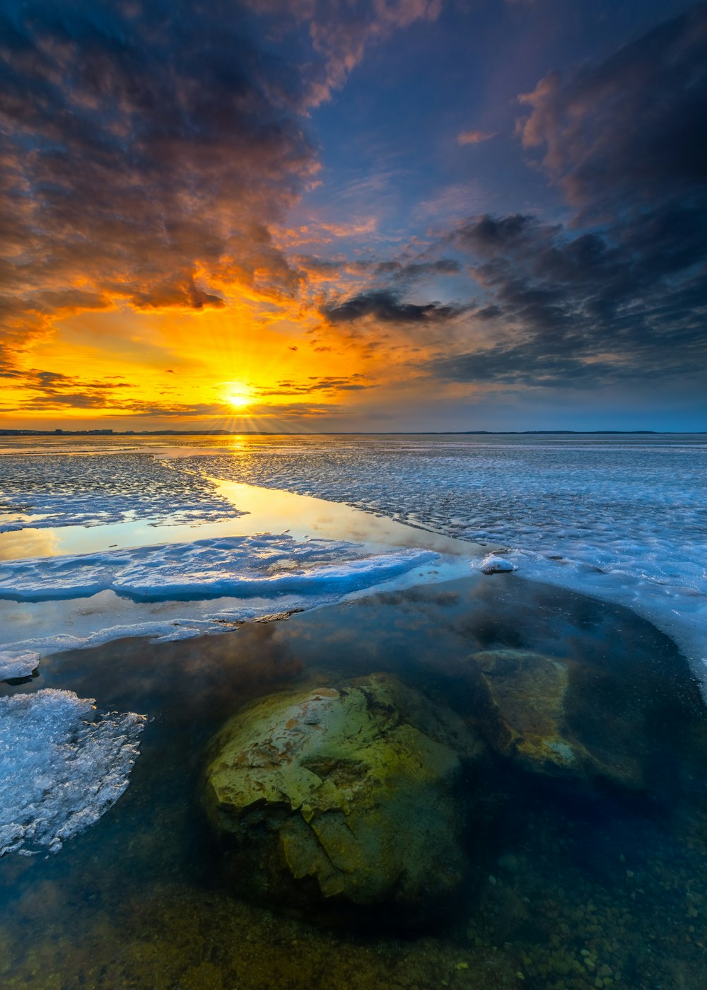 Rocas grises y marrones en la orilla del mar durante la puesta de sol