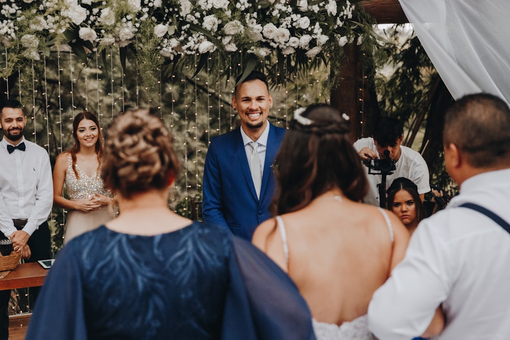 man in blue suit jacket standing beside woman in white dress