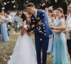 man in blue suit kissing woman in white wedding dress