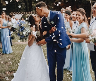 man in blue suit kissing woman in white wedding dress