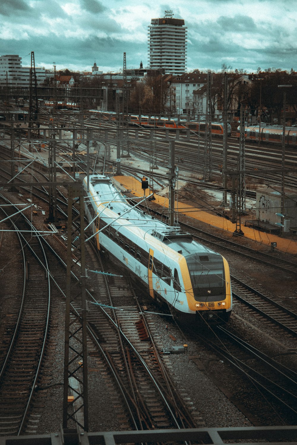 線路を走る白と黄色の列車
