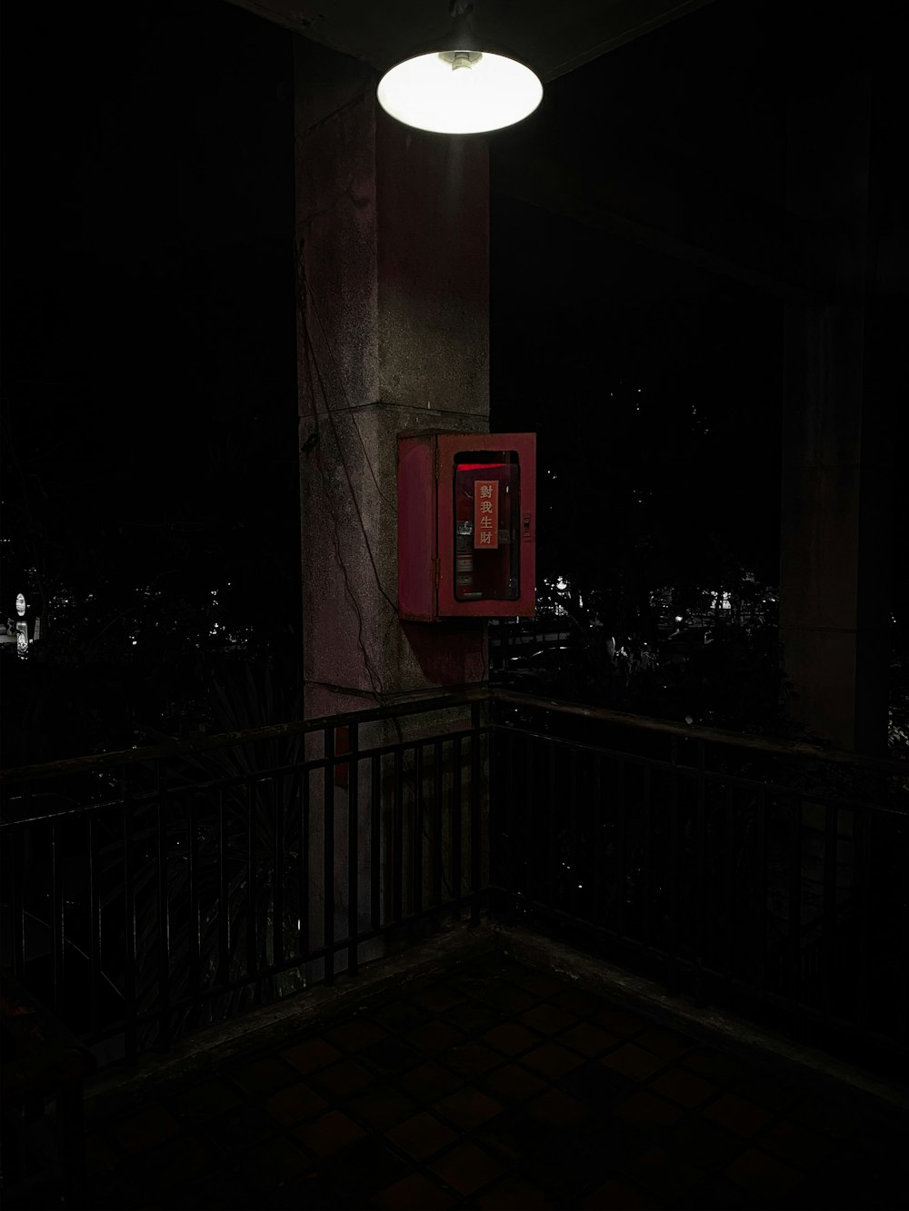 red telephone booth near green trees during night time