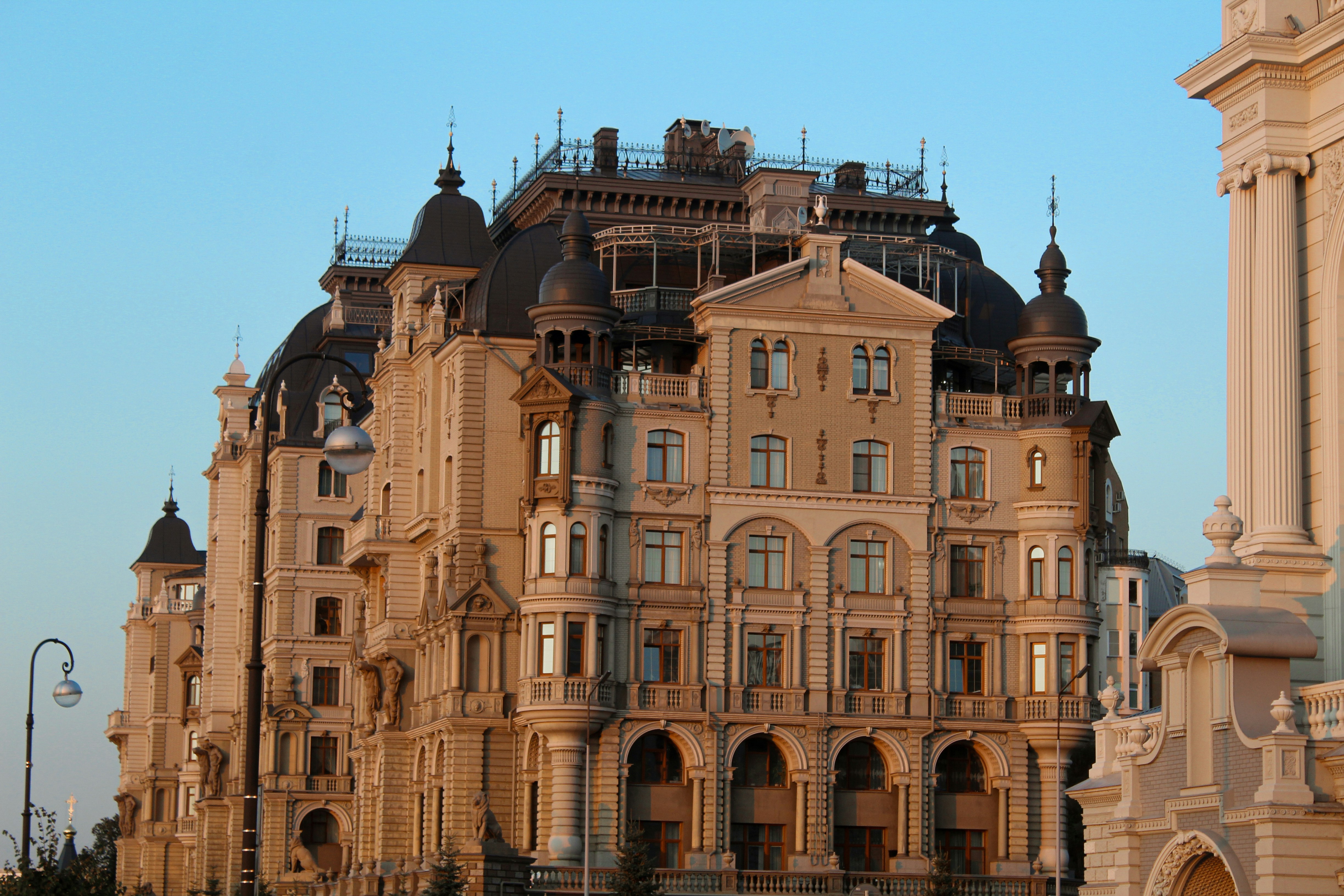 Ornate palace façade with domed turrets and arched windows stands under a clear blue sky.