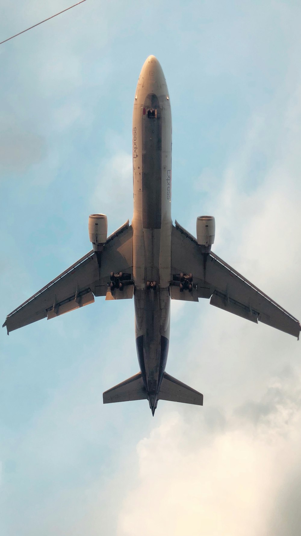 Avión gris y amarillo bajo nubes blancas durante el día