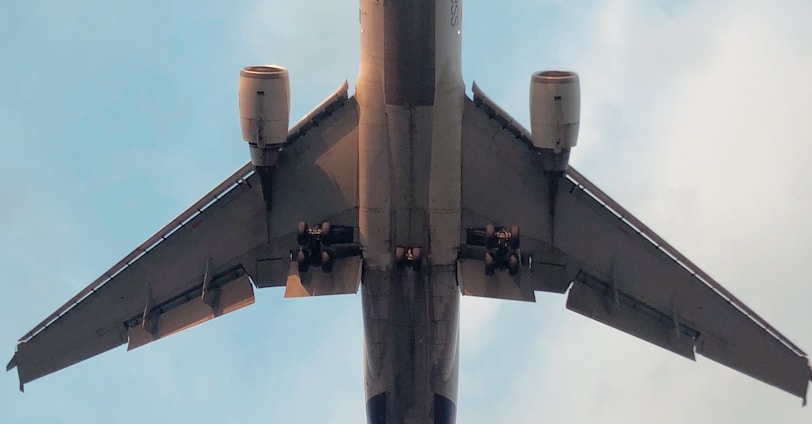 gray and yellow airplane under white clouds during daytime