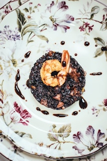 chocolate doughnut on white and red floral ceramic plate