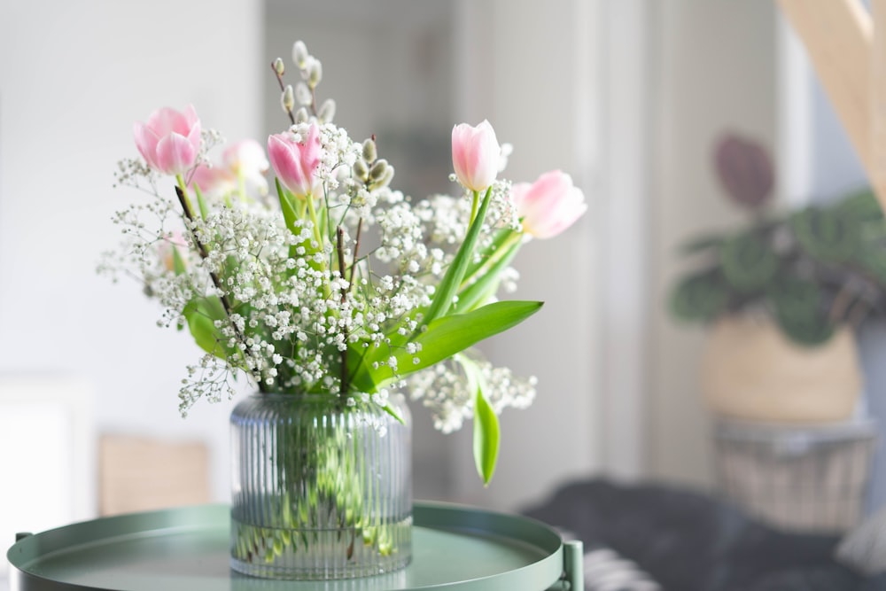 weiße und rosa Blumen in klarer Glasvase