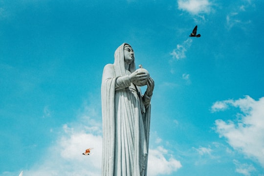 white angel statue under blue sky during daytime in Notre Dame Cathedral of Saigon Vietnam