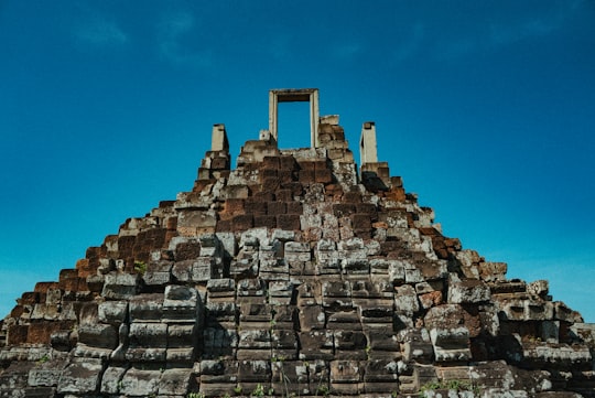 brown concrete building under blue sky during daytime in Baphuon Cambodia