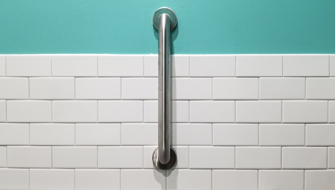 stainless steel shower head on white ceramic wall tiles