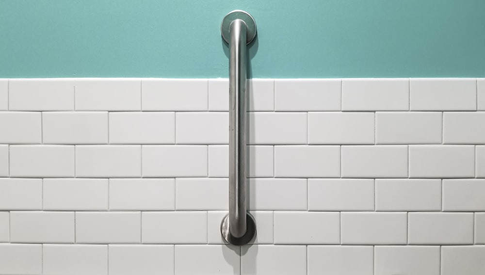 stainless steel shower head on white ceramic wall tiles